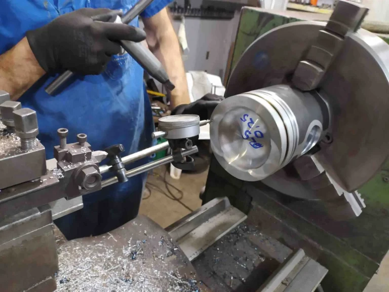 profissional usinando uma peça cilíndrica em um torno